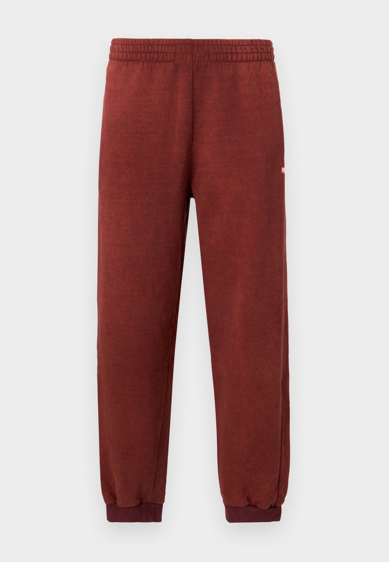 Rustfarbene Fleece-Sweatpants mit elastischem Bund und Knöchelabschlüssen, vor einem weißen Hintergrund präsentiert.
