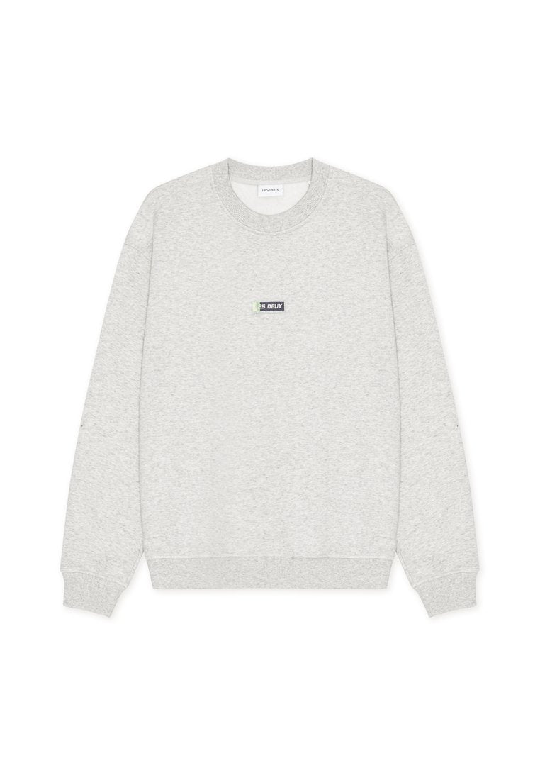 Hellgraues Sweatshirt mit Rundhalsausschnitt, Rippstrickbündchen an Ärmeln und Saum, mit einem kleinen rechteckigen "LES DEUX" Logoaufnäher in der Mitte der Brust.