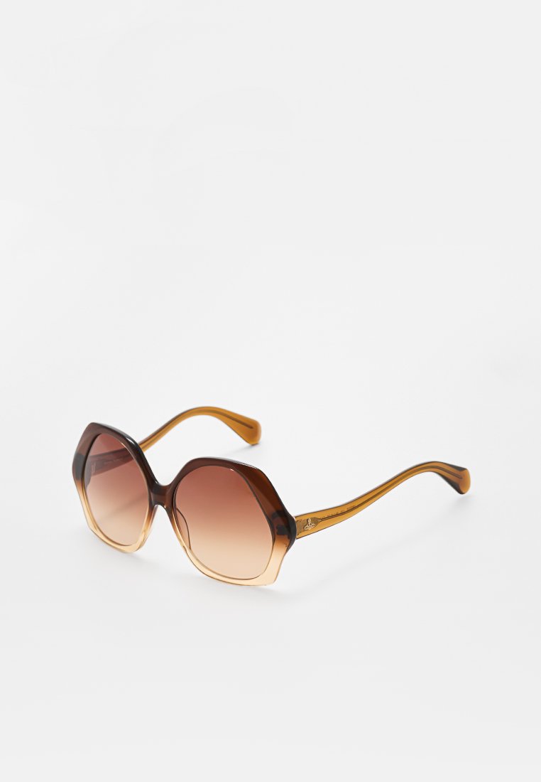 Übergroße sechseckige Sonnenbrille mit braunen Verlaufslinsen und amber-braunen, durchsichtigen Kunststoffrahmen und -büggen auf einem weißen Hintergrund.