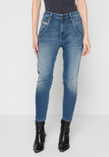 Enger Jeans in mittelblauem Denim mit mittelhohem Bund, vorderen Taschen, Bleicheffekten und einem schlanken Schnitt, kombiniert mit schwarzen Ankle Boots.