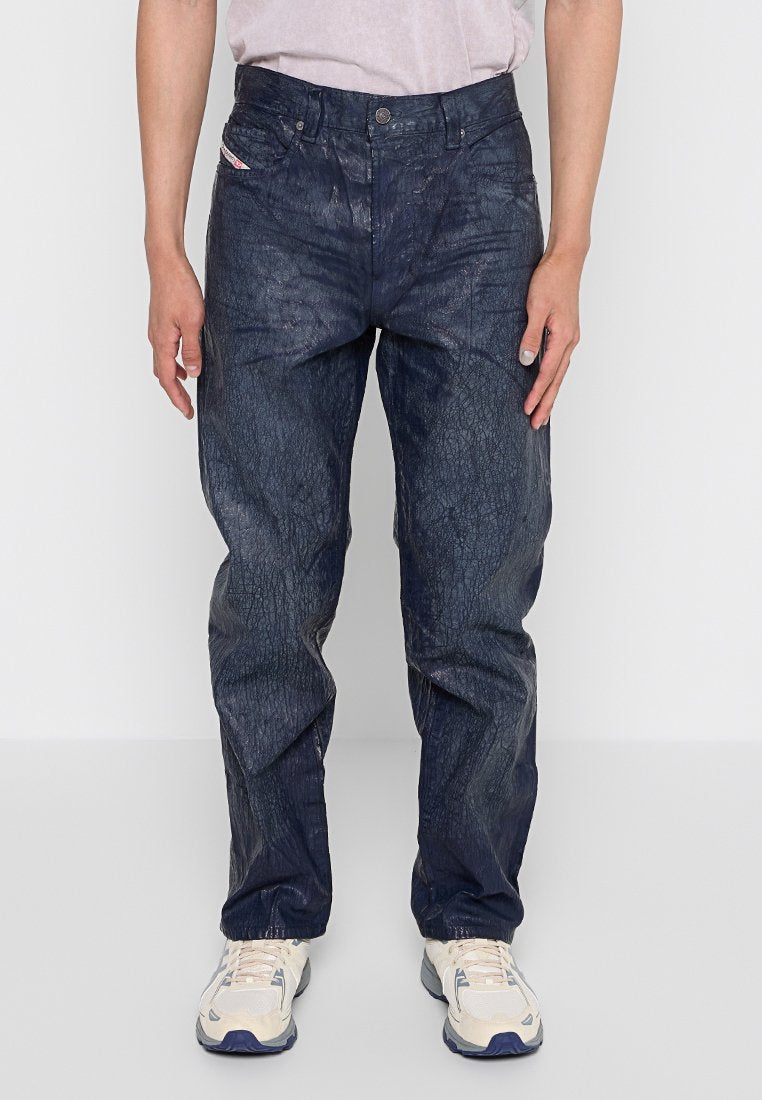 Dunkelblaue Denim-Hosen mit einer geriffelten Textur, ausgestattet mit einem klassischen Fünf-Taschen-Design und einem Knopfverschluss. Getragen mit hellen Schuhen.