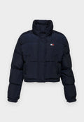 Hier ist eine kurz geschnittene, marineblaue Steppjacke mit hohem Kragen, gestepptem Design und Logodetail auf der linken Brust. Sie hat lange Ärmel und einen Frontreißverschluss.