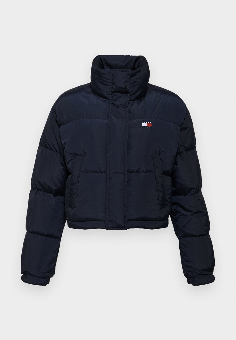 Hier ist eine kurz geschnittene, marineblaue Steppjacke mit hohem Kragen, gestepptem Design und Logodetail auf der linken Brust. Sie hat lange Ärmel und einen Frontreißverschluss.
