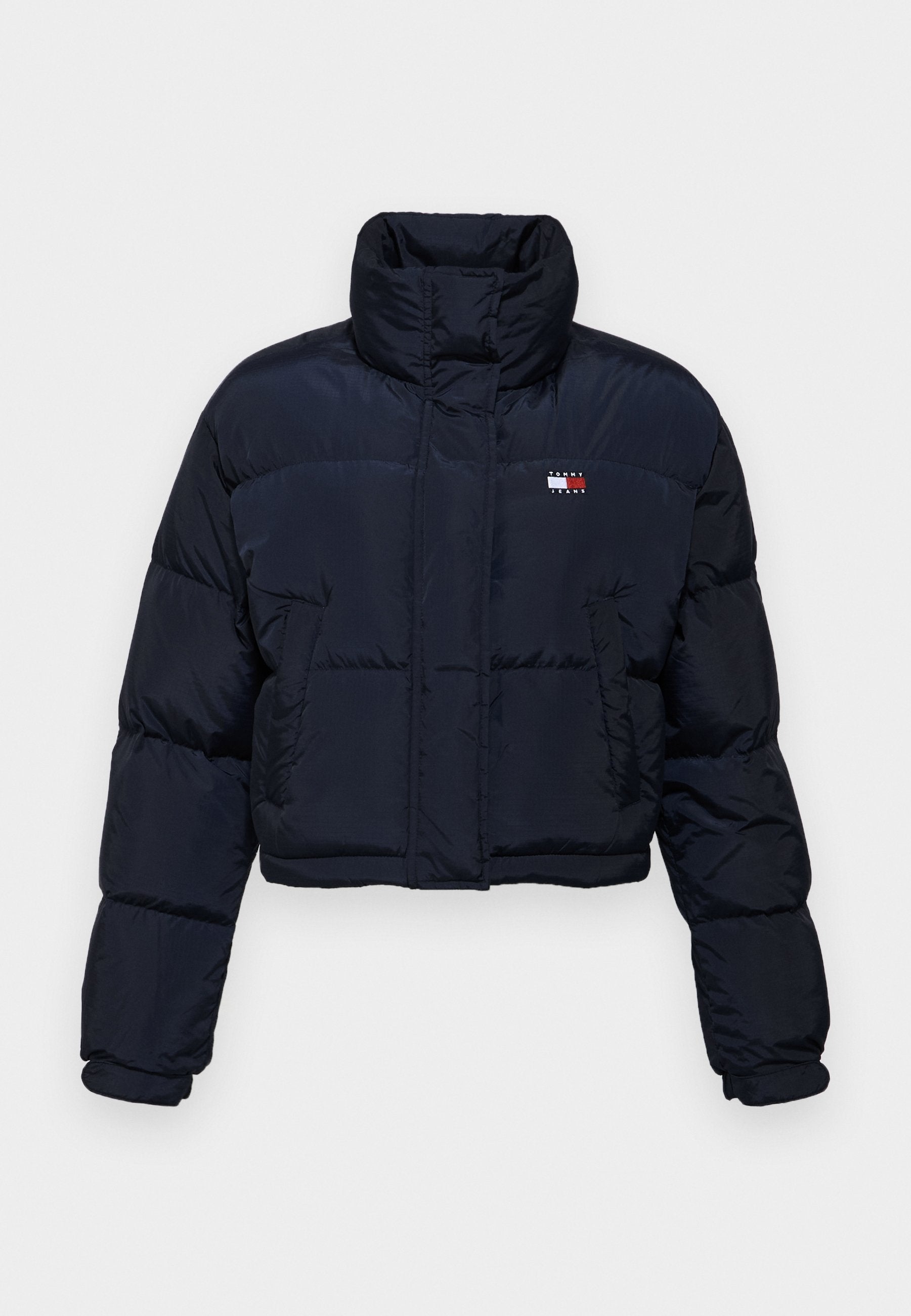 Hier ist eine kurz geschnittene, marineblaue Steppjacke mit hohem Kragen, gestepptem Design und Logodetail auf der linken Brust. Sie hat lange Ärmel und einen Frontreißverschluss.