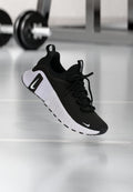 Schwarzer Sportschuh mit strukturiertem Stoffobermaterial, weißer Sohle und auffälligem Schnürsystem. Verfügt über ein Nike-Logo und ein weiches, gepolstertes Design.
