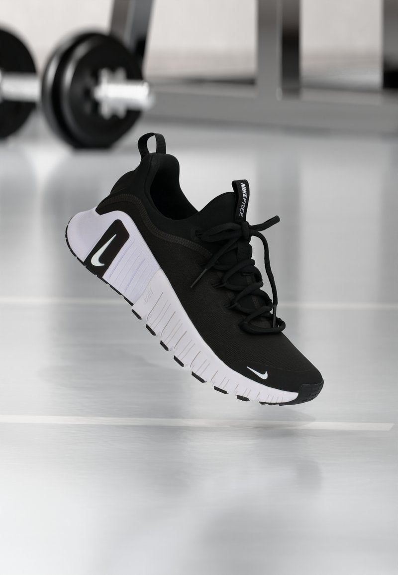 Schwarzer Sportschuh mit strukturiertem Stoffobermaterial, weißer Sohle und auffälligem Schnürsystem. Verfügt über ein Nike-Logo und ein weiches, gepolstertes Design.