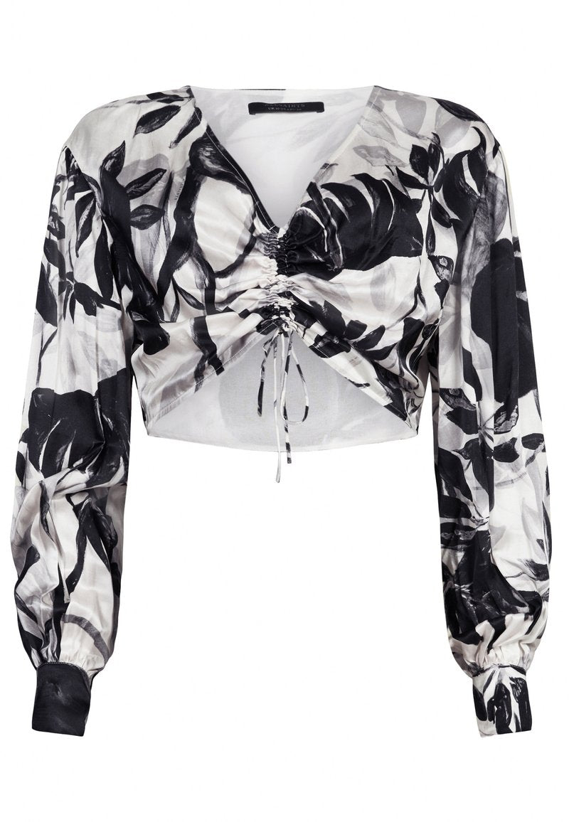 Schwarz-weißer Langarm-Crop-Top mit abstraktem Blattdruck und gerafftem Kordelzugdetail in der Mitte vorne.