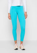 Türkisfarbene Sportleggings mit glatter Textur, hoher Taille und Logodetail. Kombiniert mit hellen Sneakers mit pinken Akzenten.