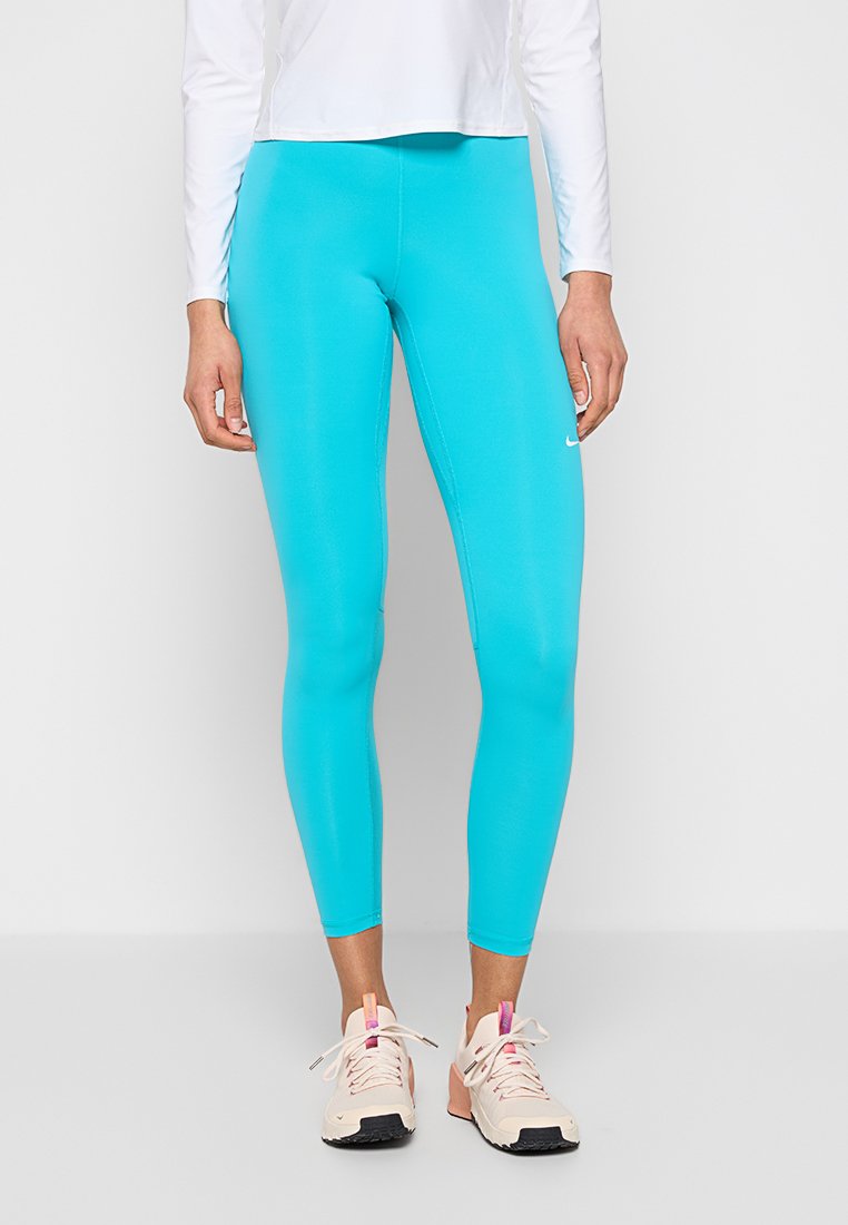 Türkisfarbene Sportleggings mit glatter Textur, hoher Taille und Logodetail. Kombiniert mit hellen Sneakers mit pinken Akzenten.
