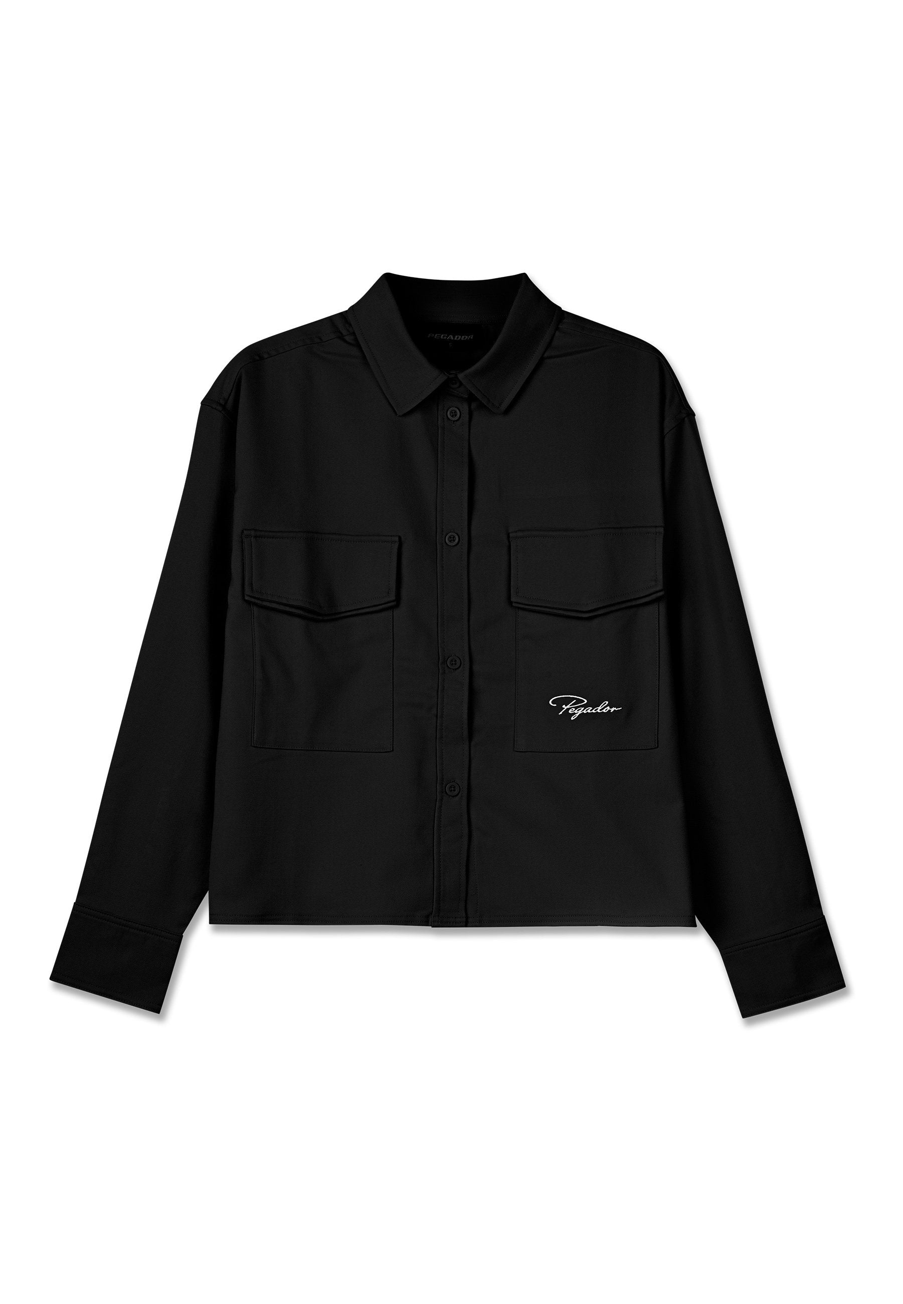 Schwarzes Cropped-Shirt mit spitzem Kragen, doppelten Brusttaschen, Knopfleiste und gesticktem Logo auf der linken Seite. Glatte Stoffstruktur.