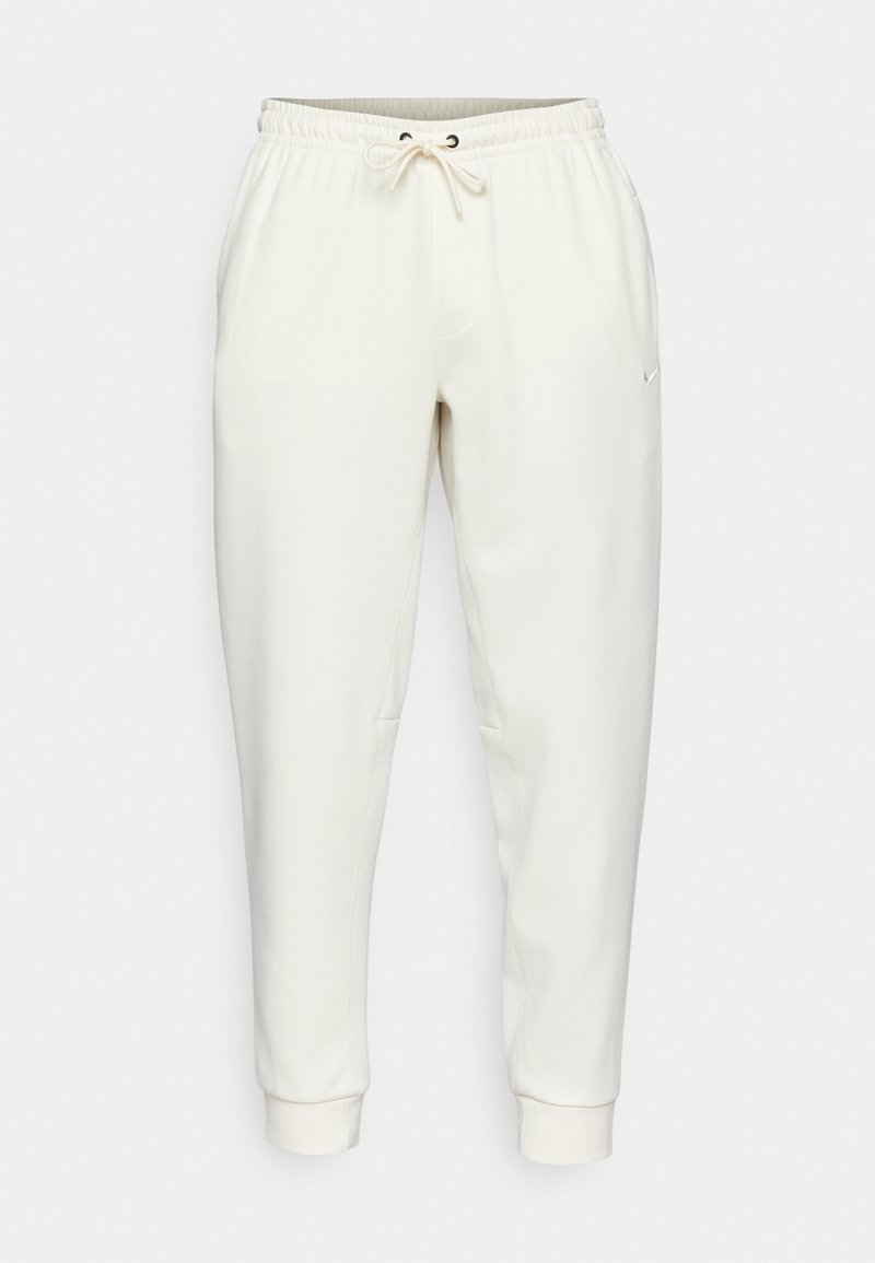 Weiße Sweatpants mit einem verstellbaren Bund, schmal zulaufenden Beinen, Seitentaschen und einem kleinen Logo. Hergestellt aus weichem, glattem Stoff.