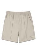Beige Sportshorts aus weichem Material. Mit einem elastischen Bund, zwei Seitentaschen und einem dekorativen gestickten Etikett am Saum.
