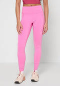 Leuchtend pinke Leggings aus dehnbarem Stoff, mit hohem Bund und schlankem Schnitt, kombiniert mit hellen Sportschuhen.