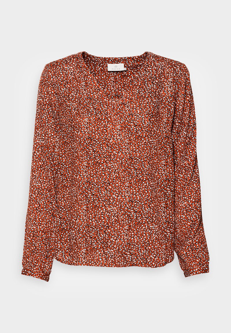 Langärmlige Bluse mit V-Ausschnitt, aus leichtem Stoff gefertigt. Hat eine rote Basis mit einem weißen und schwarzen abstrakten Muster.