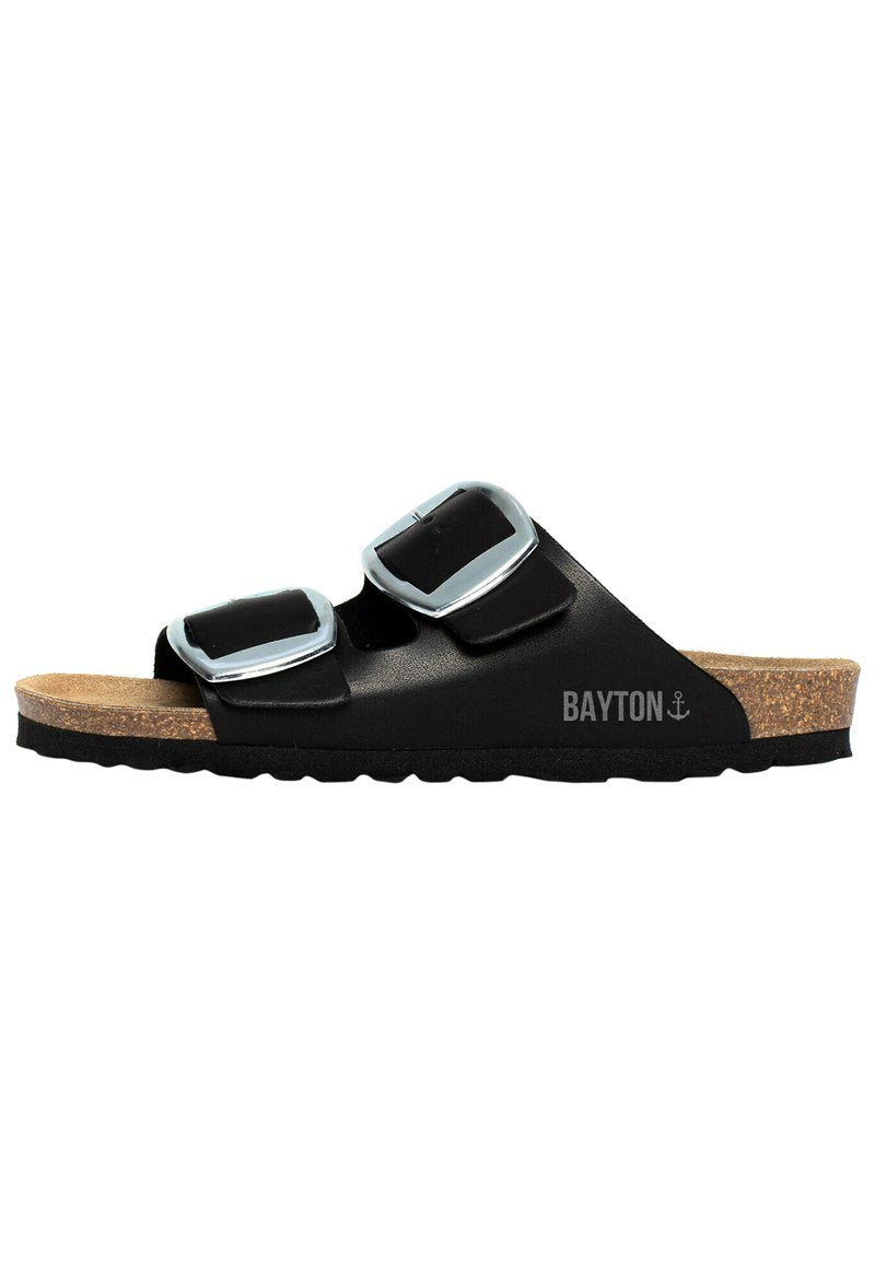 Schwarze Slipper-Sandalen mit zwei großen silbernen Schnallen, Korkfußbett, texturierten schwarzen Sohlen und "BAYTON"-Logo an der Seite.