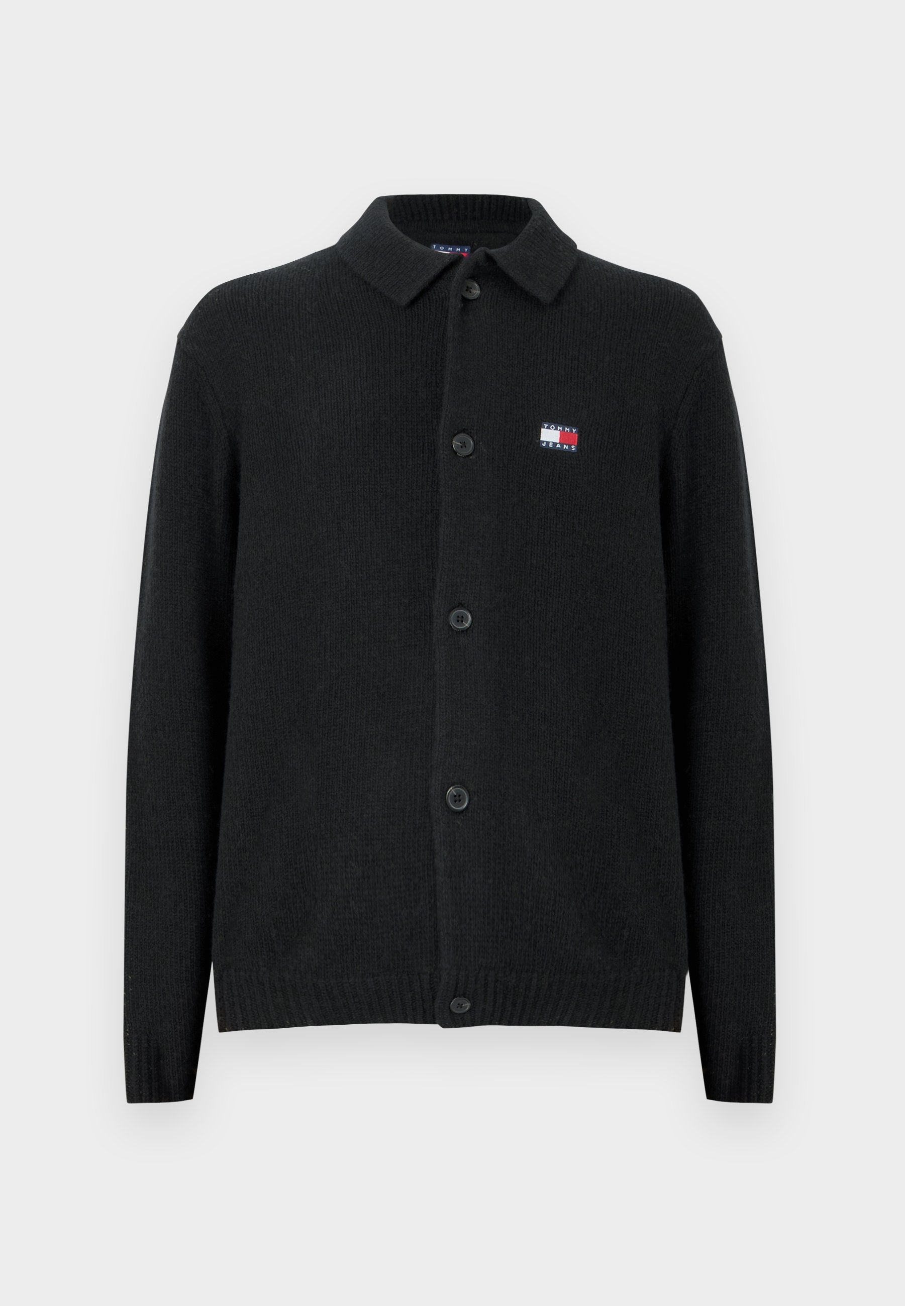 Schwarzer Wollcardigan mit Kragen, Knopfleiste und gerippten Bündchen. Kleines Logo in Rot, Weiß und Blau auf der linken Brust.