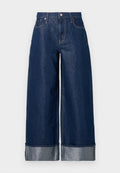 Dunkelblaue, weite Jeans mit hohem Bund, Fünf-Taschen-Design und umgekrempelten Säumen, die ein helleres Innenfutter zeigen.