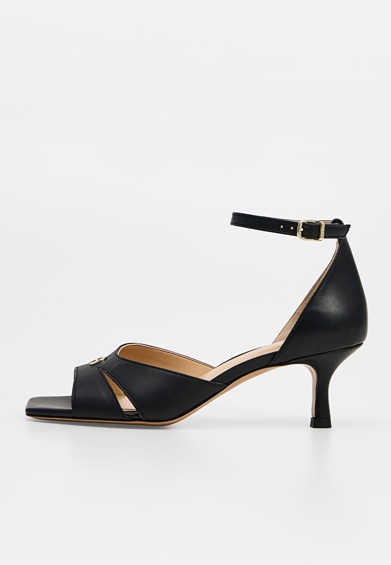 Schwarze Leder-Kitten-Heel-Sandale mit offenem Zehenbereich, Knöchelriemen und goldener Schnalle, mit Cut-out-Details an den Seiten.