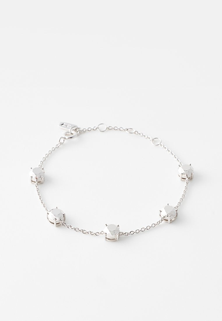 Silbernes Kettenarmband mit fünf gleichmäßig verteilten runden klaren Edelsteinen und einem Karabinerverschluss vor weißem Hintergrund.