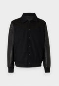 Schwarze Jacke mit Wollkörper und Lederärmeln. Mit einer durchgehenden Knopfleiste, seitlichen Taschen sowie gerippten Bündchen und Saum. Glatte Textur im gesamten Bereich.