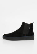 Schwarzer Wildleder-Stiefelette mit elastischen Seitenpanelen, strukturierter Gummisohle und schlanker Silhouette. Mit kontrastierenden Ziernähten.