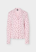 Rosa langärmeliges Pyjamaoberteil mit dunkelroten Punkten, Knopfleiste vorne und einem Reverskragen.