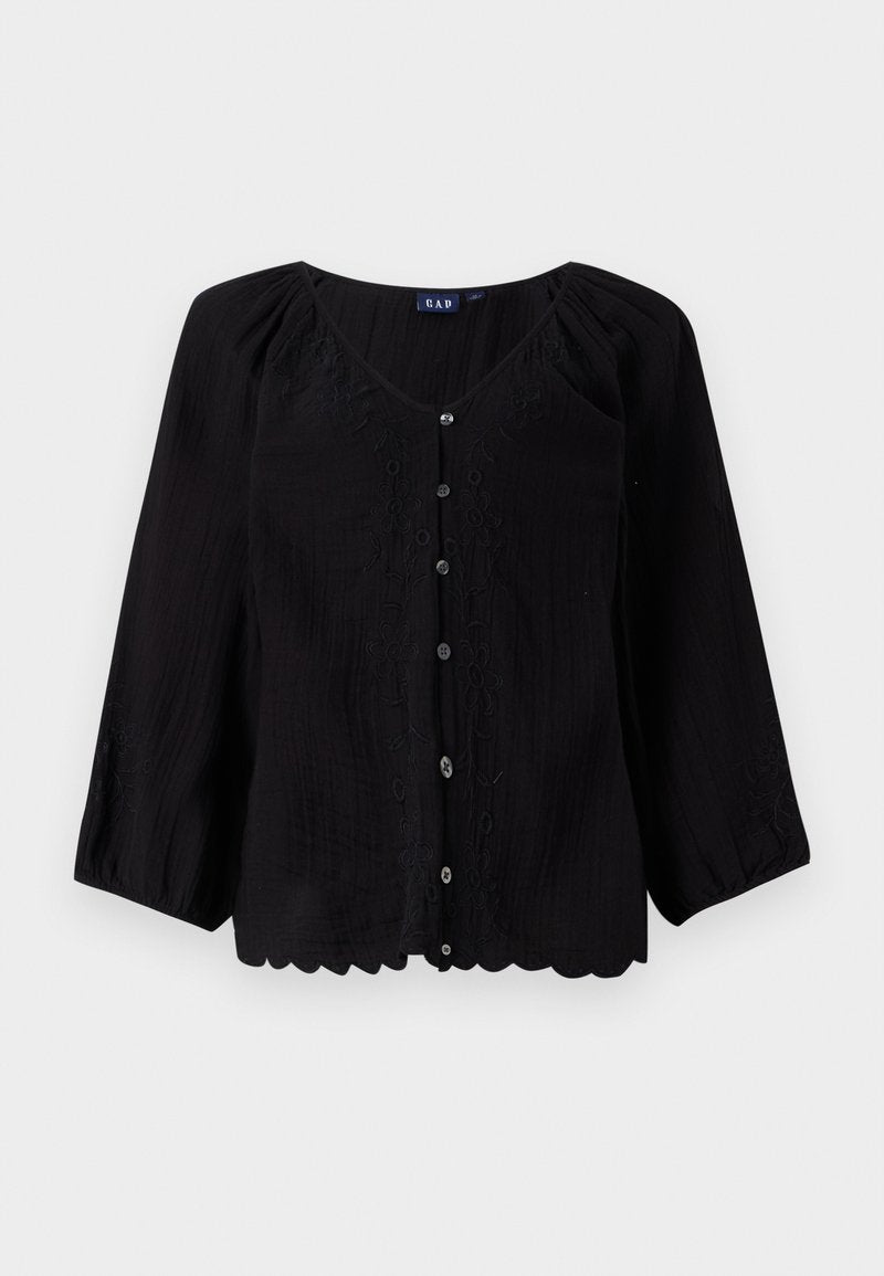 Schwarze Bluse mit Knöpfen, dreiviertel Ärmeln, V-Ausschnitt, strukturiertem Stoff und floralem Stickerei an der Vorderseite. Mit gewelltem Saumdetails.