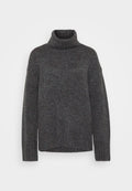 Grauer Strick-Turtleneck-Pullover mit gerippter Textur, langen Ärmeln und einem lockeren Schnitt. Das Material wirkt weich und voluminös. Der untere Saum ist gerade.