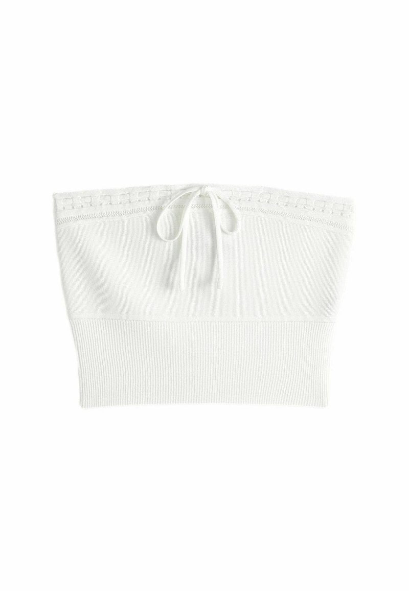 Weißes, geripptes Crop-Top mit Kordelzug-Verschluss und dekorativem Besatz entlang des Ausschnitts. Weicher, gestrickter Stoff mit figurbetontem Design.