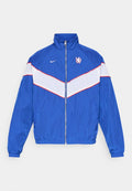 Blaue Nylonjacke mit weißen und roten diagonalen Streifen, mit Reißverschluss, hohem Kragen und besticktem Logo auf der Brust. Elastische Bündchen und Taillenbund.