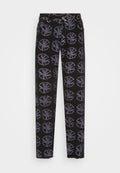 Schwarze Denim-Hosen mit einem wiederholten grafischen Muster in Hellgrau. Das Design umfasst kreisförmige Motive mit blattähnlichen Akzenten und einem fransigen Saum.