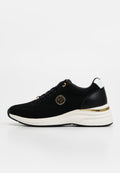 Schwarzer Strick-Sneaker mit weißer Sohle, goldenen Akzenten, Schnürverschluss vorne und rundem goldfarbenem Emblem an der Seite, in rechter Seitenansicht gezeigt.