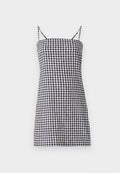 Schwarz-weiß kariertes Kleid mit dünnen Spaghetti-Trägern, gerader Silhouette und tailliertem Oberteil. Baumwollmaterial mit glatter Textur.