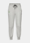 Hellgraue Sweatpants mit schwarzem Kordelzug, elastischen Bündchen, FC Barcelona-Logo auf dem linken Oberschenkel und neongelbem Nike-Swoosh auf dem rechten Oberschenkel.