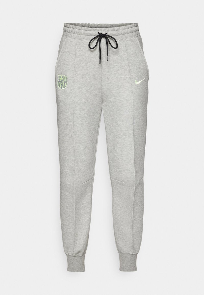 Hellgraue Sweatpants mit schwarzem Kordelzug, elastischen Bündchen, FC Barcelona-Logo auf dem linken Oberschenkel und neongelbem Nike-Swoosh auf dem rechten Oberschenkel.