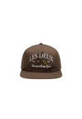 Braune Snapback-Mütze aus Stoff; mit weißem, gesticktem Text "LES DEUX" und "International Sporting Goods" sowie grafischen Akzenten.