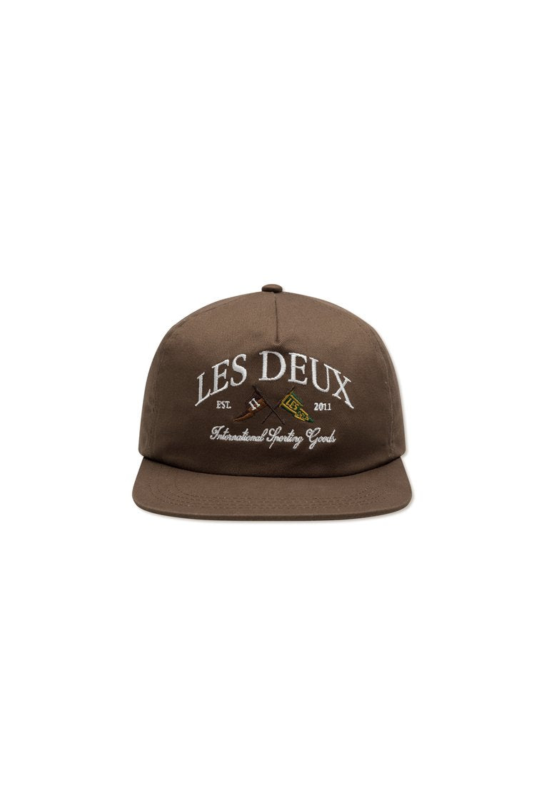 Braune Snapback-Mütze aus Stoff; mit weißem, gesticktem Text "LES DEUX" und "International Sporting Goods" sowie grafischen Akzenten.