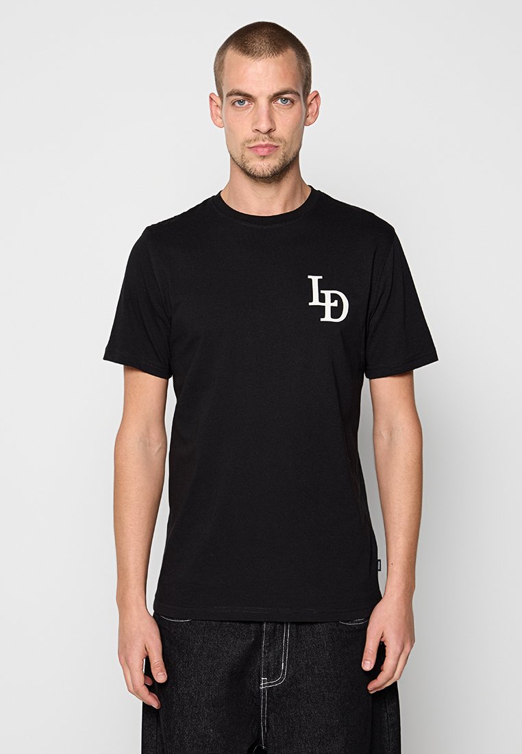 Schwarzes Baumwoll-T-Shirt mit kurzen Ärmeln und Rundhalsausschnitt. Mit einem weißen Logo auf der linken Brustseite. Glatte Textur, legere Passform.