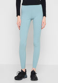 Hellblaue Leggings aus dehnbarem Stoff mit hoher Taille und figurbetonter Silhouette, kombiniert mit schwarzen Sportschuhen.
