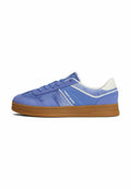 Leder-Sneaker in blauem Wildleder und Stoff mit weißen Akzenten und einer braunen Gummisohle, mit dem Branding "Tommy Jeans" an der Seitenwand.