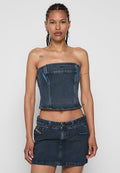 Jeans-Zweiteiler mit einem trägerlosen Cropped-Top mit blauen Nähten und einem hochtaillierten Minirock, beide im dunklen Waschlook.
