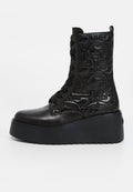 Schwarze, aus Leder gefertigte Schnür-Stiefeletten mit gemusterten Seiten, dicker Plateausohle und betontem Absatz. Verfügen über eine runde Zehenpartie und eine strukturierte Oberfläche.