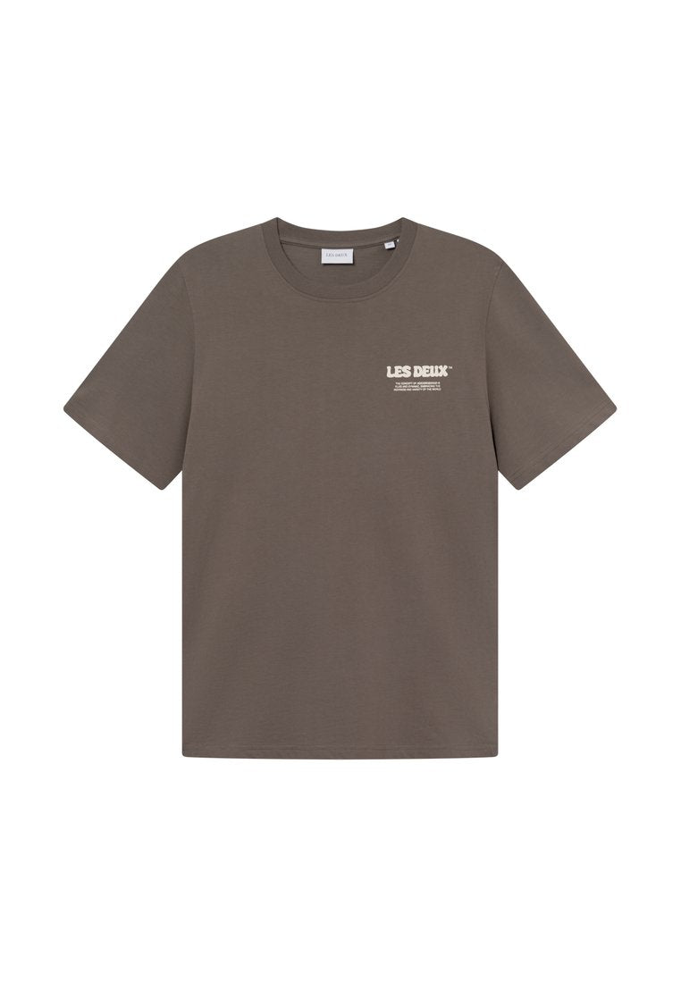 Braunes Baumwoll-T-Shirt mit Rundhalsausschnitt, kurzen Ärmeln und einem kleinen weißen Logo auf der linken Brust. Glatte Textur, lässiger Schnitt.