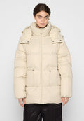 Beige Steppjacke mit hohem Kragen, Reißverschluss, verstellbaren Kordeln in der Taille und Druckknopfakzenten an der Kapuze.