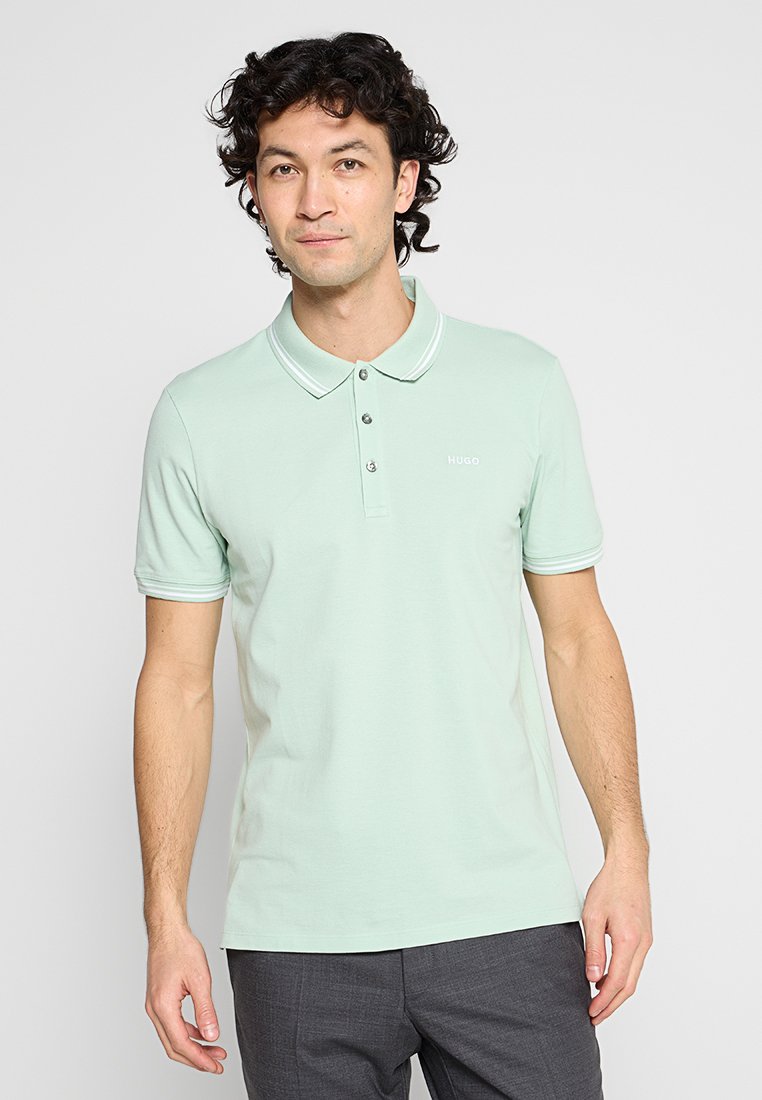 Hellgrünes Poloshirt aus weichem Stoff mit klassischem Kragen, einer Drei-Knopf-Leiste und weißen Akzentstreifen am Kragen.