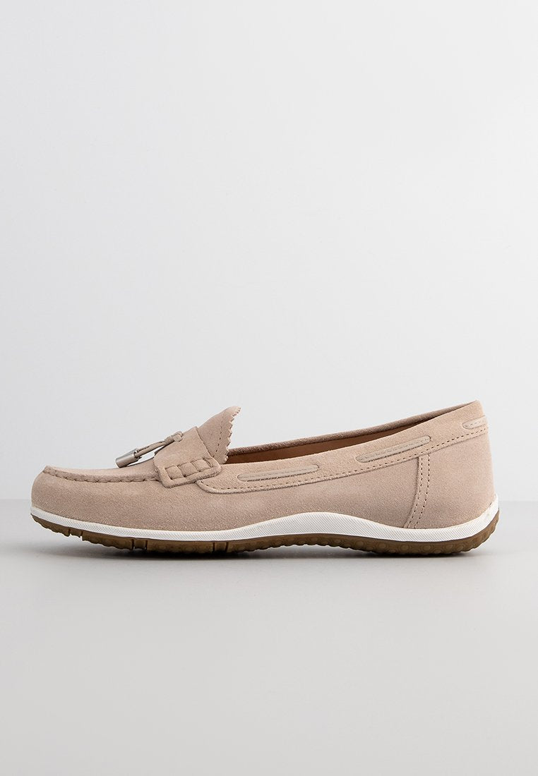 Beige Wildleder Slipper mit einem dekorativen gestickten Obermaterial, einem silbernen Akzent, einer weißen Sohle und einer strukturierten braunen Gummisohle.