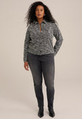 Grau und schwarz gemusterter Hemdchen-Pullover mit Kragen, kombiniert mit dunklen Jeans und schwarzen spitzen Stiefeln. Glatte Textur und taillierte Passform.
