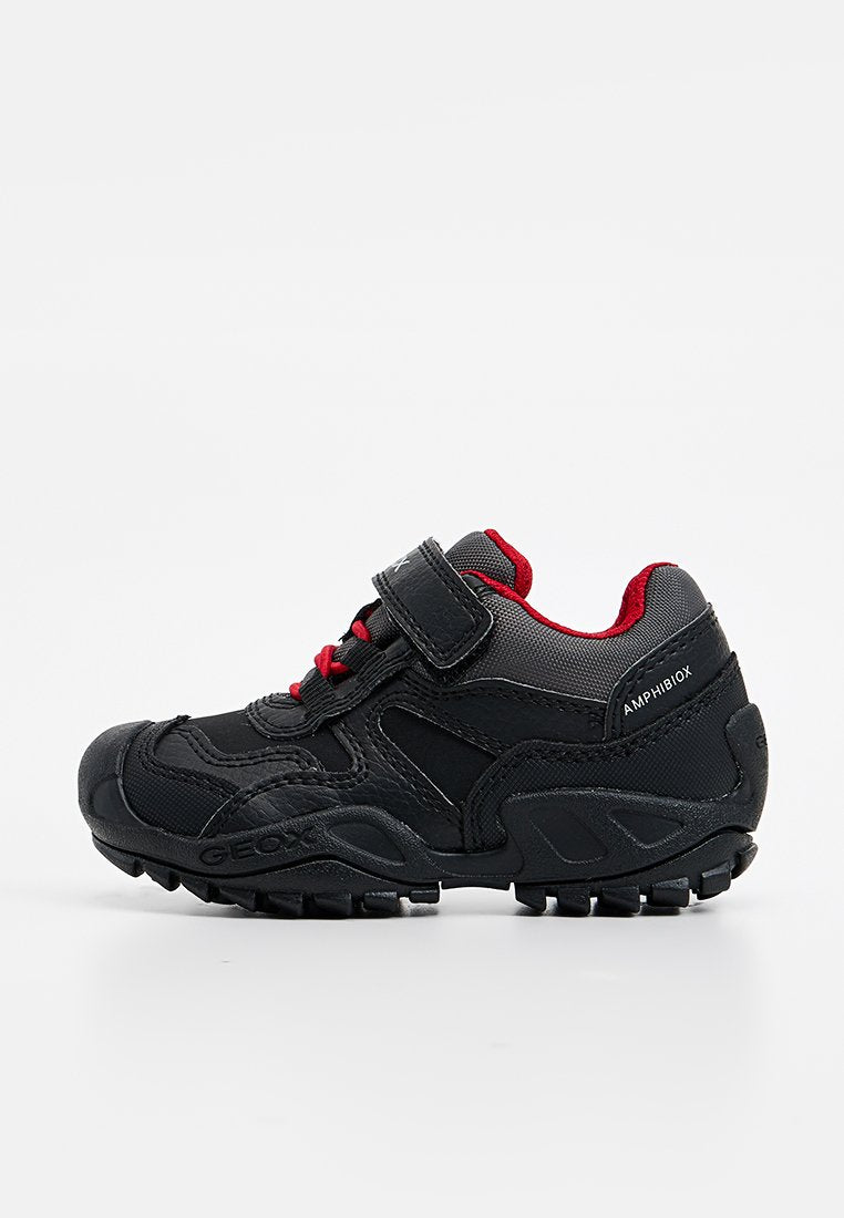 Schwarze und rote Kinder-Sportschuhe mit Klettverschluss, Schnürung vorne, strukturiertem Sole und "Amphibiox"-Markierung an der Seite.