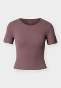 Kurzärmeliges, figurbetontes T-Shirt in gedämpftem Mauve, aus feuchtigkeitsableitendem Stoff. Verfügt über einen Rundhalsausschnitt und eine glatte, weiche Textur.
