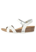 Weiße Sandalen mit Riemchen und Kork-Wedge-Sohle, ausgestattet mit einer silbernen Schnalle und einer strukturierten Innensohle. Obermaterial aus glattem Synthetik und Gummisohle.